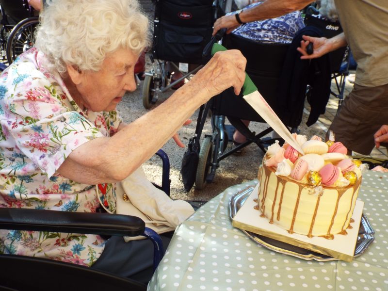 elderly woman cutting cake at rockdale 75th celebration